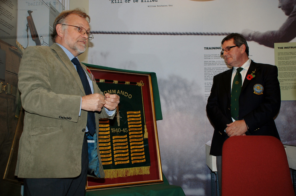 Ron Lane presenting his framed Commando Honours Battle Flag to the West Highland Museum