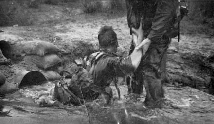 Gnr. L. Stewart being assisted out of the water tunnel by Lt Dalton, July 1964