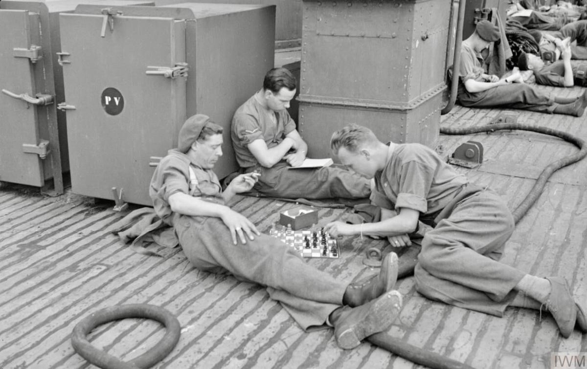 No.4 Cdos.,LBdr. Spencer plays chess with Pte. Gulvin. LCpl Preece reads book. June 1944