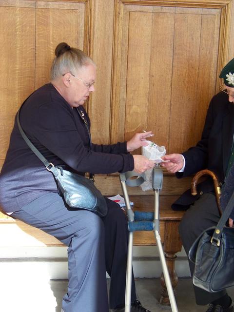 Sylvie Townshend taking money from Jim Petrie, No.6 Commando.