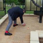 Ron 'Red Socks' Lain places a poppy on Bob Bartholemew's paver