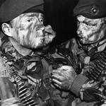 A Royal Marine of 3 Commando Brigade helps another to apply camouflage face paint in preparation for the San Carlos landings on
