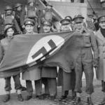 British officers with a captured Nazi flag after the raid.